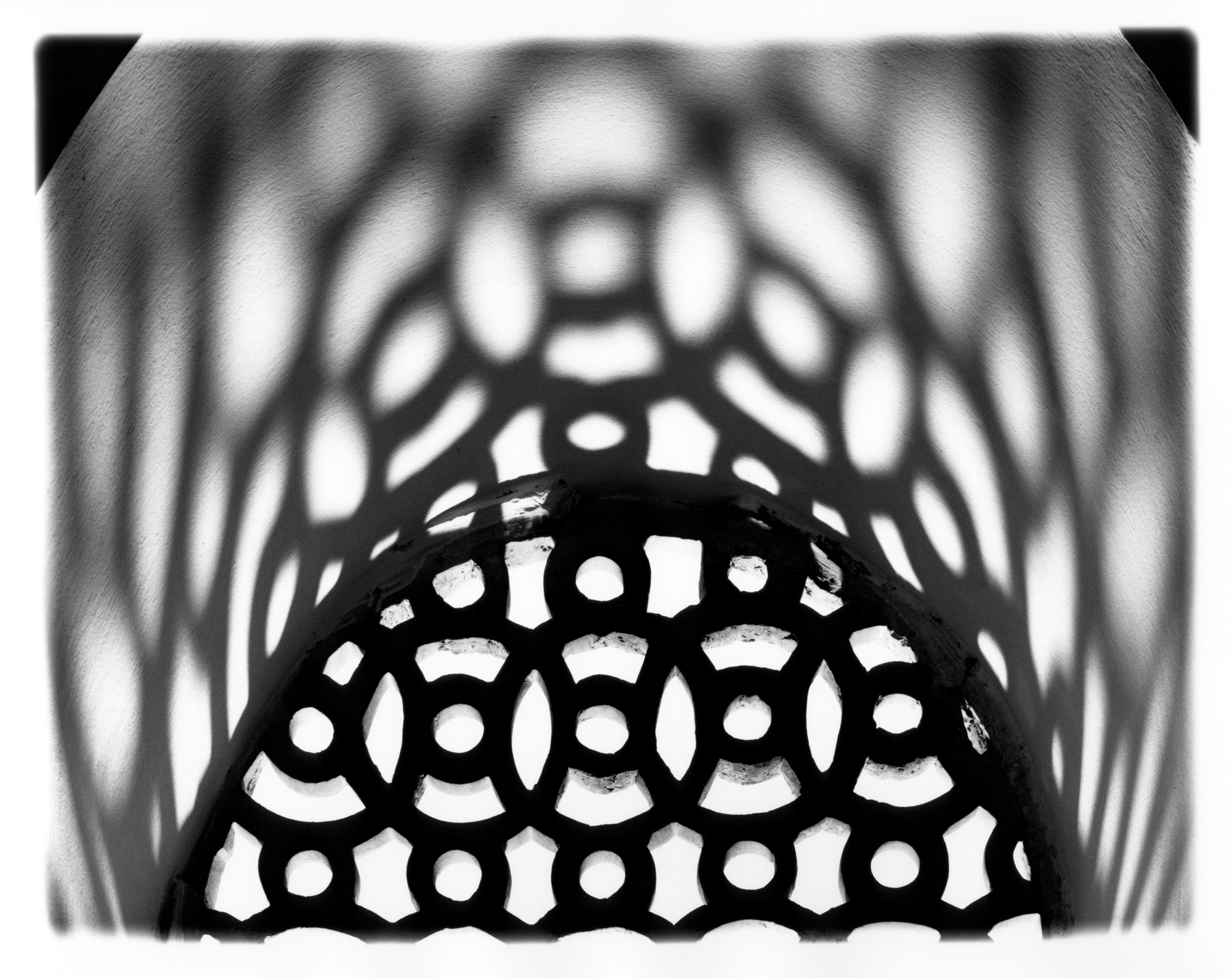 From the Portfolio "Umayyad Grilles." Photographs created in Damascus National Museum from reconstructed artifacts discovered in the ruins of the Umayyad palace Qasr al-Hayr al-Gharbi, built by the Caliph Hisham ibn Abd al-Malik in the early 8th c. on route from Damascus to Palmyra, Tadmur. File No. 0512-52-4_2. Tympanum Stucco Grilles, Interlacing Circles, Shadow Cast on Arch.